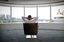 Rear View Of Senior Businessman Sitting On Chair In Office