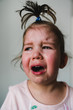 © Giorgio Magini/Stocksy - Crying Toddler Girl with Funny Topknot