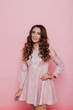 © dmitriisimakov - Portrait of a beautiful fashionable woman with hair curls in a pink dress