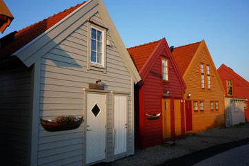 Pretty Norwegian houses on island of Fedje in the first rays of the morning sun. Village of Fedje, Norway.