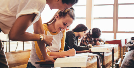 Girl attending a class being helped by her teacher