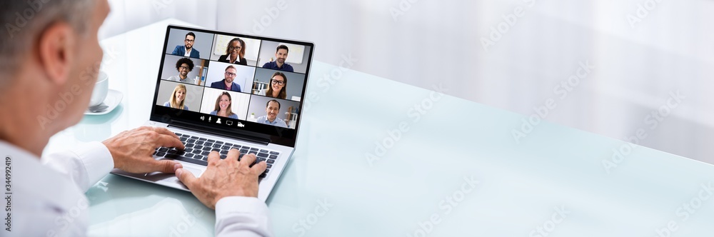 Businessman Videoconferencing With Colleague On Laptop - obrazy, fototapety, plakaty 