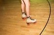 © Luis Garcia - Legs of people roller skating in a wood skate ring.