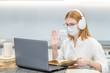 © Ermolaev Alexandr - Young girl wearing medical protective mask uses laptop at home. Distance learning. Quarantine and coronavirus epidemic concept