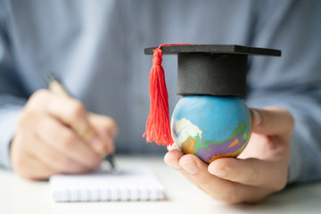 Wall Mural - Study Aboard School  Education Global world, Graduation Student holding Earth globe model map cap with hands writing pen.global business study abroad education innovation to educational Concept