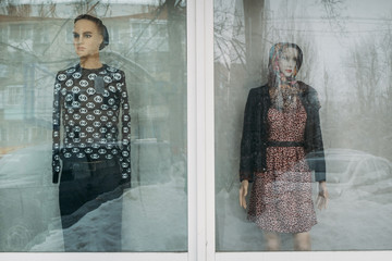 two mannequins man and woman close in a shop window during a sale