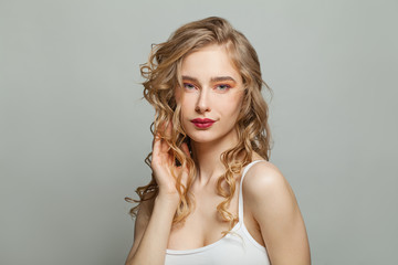 Perfect woman with long blonde curly hair on white background