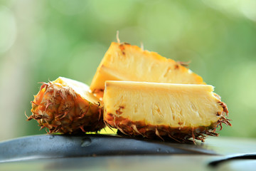 Wall Mural - Sliced pineapple in the banana leaf isolated on blended green background