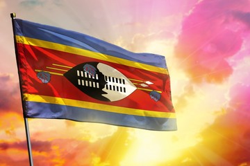 Fluttering Swaziland flag on beautiful colorful sunset or sunrise background. Success concept.