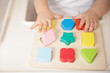 © irena_geo - Toddler arranges and sorts toys by color and geometric shape. Educational and development wooden toys. Montessori games