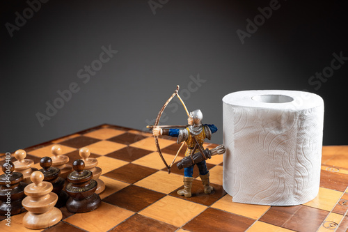 Fotomural Archer defending a roll of toilet paper from an army of pawns on a chessboard