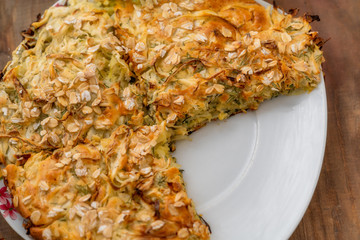 Lazy pie with cabbage and dill according to the Turkish recipe on a wooden table