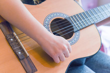 A Girl Learns To Play Guitar At Home Close Up On Hands