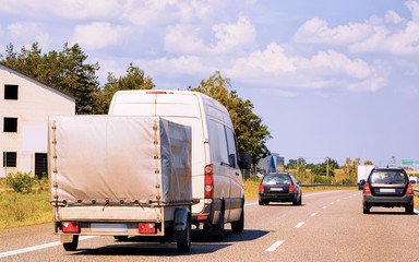 Wall Mural - Mini van with Car trailer on roadway in Poland reflex