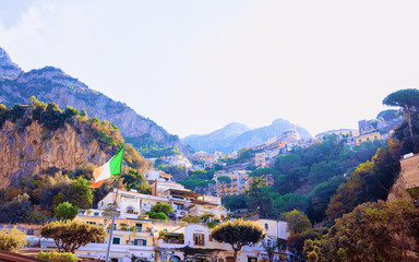 Wall Mural - Citiscape with Italian flag and houses at Positano town reflex