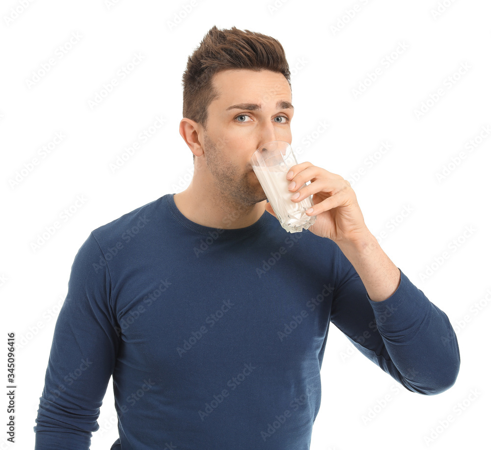 Young man with glass of milk on white background
