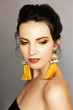 Beautiful girl with yellow makeu-up and earrings