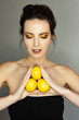 Beautiful girl with yellow makeu-up holding three lemons
