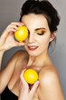 Beautiful girl with yellow makeu-up holding two lemons