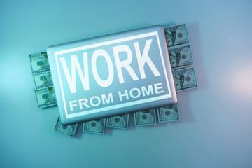 Aufkleber - Words work from home on a  cloused silver laptop and 100 dollars cash night online in the color light on a table night background. Top view.
