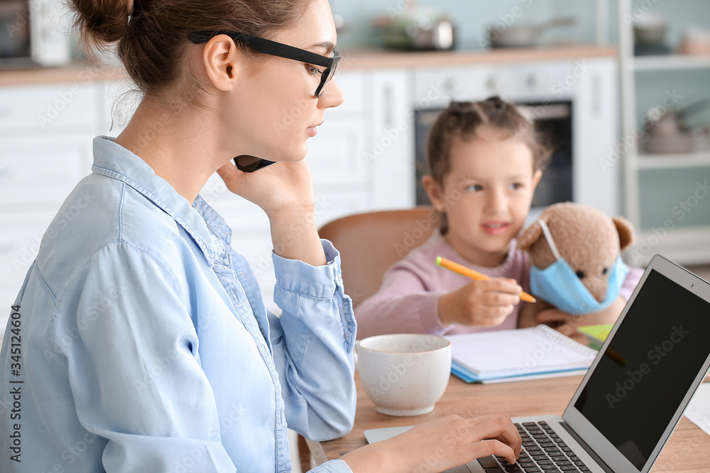 Working mother with little daughter at home