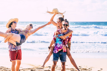 Wall Mural - Happy group of caucasian young people in tourist free activity - tourism and travel millennial couples have fun at the beach with blue ocean and sky in background - cheerful and laughs real life