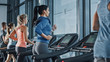 © Gorodenkoff - Fit Athletic Woman Running on the Treadmill, Doing Her Fitness Exercise. Muscular Women and Men Actively Training in the Modern Gym. Sports People Workout in Fitness Center. Side View Shot