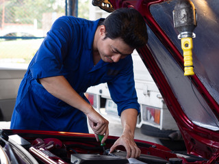 garage worker concept. car mechanic checks the engine of a vehicle.Professional mechanic providing car repair and maintenance service in auto service