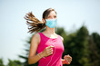 © Minerva Studio - Woman running at the park wearing a mask - coronavirus concept