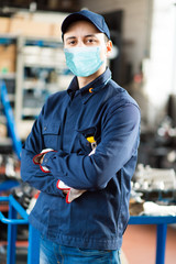 Canvas Print - Young mechanic portrait wearing a mask - coronavirus concept