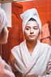 © blanke1973 - A young girl is looking in the mirror in a white bathrobe