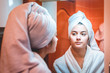 © blanke1973 - A young girl is looking in the mirror in a white bathrobe