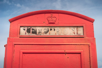 An old British red telephone box, weathered by the salty beach air at Studland, near Sandbanks, Dorset, UK