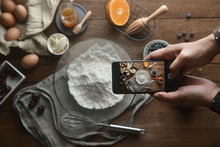 The Top View Of The Hand Take Photo Of Ingredients And Method Bakery Or Dessert With The Smartphone On The Table. Tutorial Food Photography, A Lifestyle To Social Media.Flat Lay Photography.