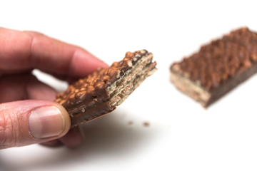 Poster - Closeup of broken chocolate bar with puffed rice in hand on white background