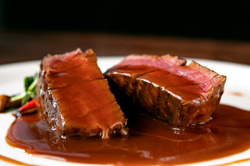 Grilled beef Steak filet Mignon medium rare pour demi-glace sauce