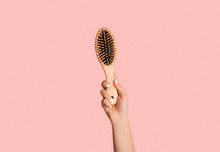 Closeup Of Millennial Girl Holding Wooden Hairbrush On Pink Background