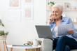 © Prostock-studio - Confident senior woman working with laptop and papers at home