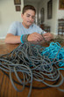 Teenage boy works on bracelet making craft in home.