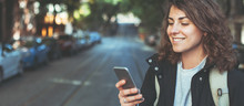 Handsome Smiling Woman With Mobile Phone Walking On The Street. Wide Screen, Panoramic