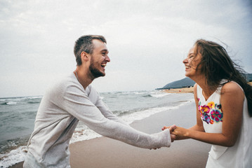 Wall Mural - 
Happy lovers have a cheerful vibes on sea beach at sunset 
