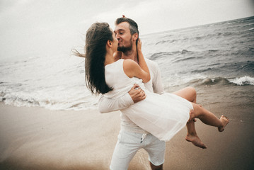 Wall Mural - 
Happy lovers have a cheerful vibes on sea beach at sunset 
