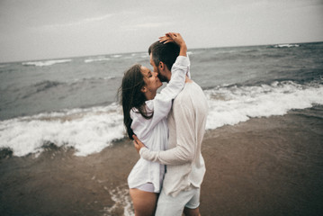 Wall Mural - Happy lovers have a cheerful vibes on sea beach at sunset 