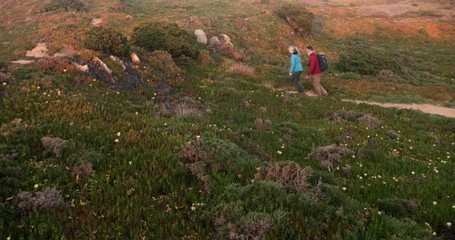 senior caucasian couple hiking on trail on top of hill