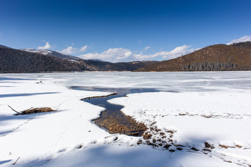 Wall Mural - Potatso National Park or Pudacuo National Park during winter with mountain and frozen lake scenery