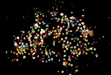 bright crumbs are sprinkled for cakes on a black background.