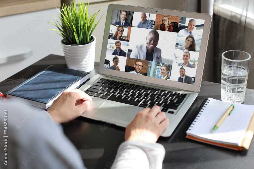 Business woman talking to her colleagues in video conference. Multiethnic business team working from home using laptop. - obrazy, fototapety, plakaty 