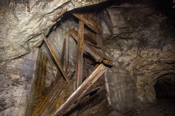 Underground abandoned iron ore mine tunnel with wooden orechute