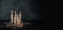 Six Burning Candles And The Star Of David Against On A Dark Gray Background Wall.