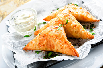 Plate of traditional arabic sambusek with sauce.